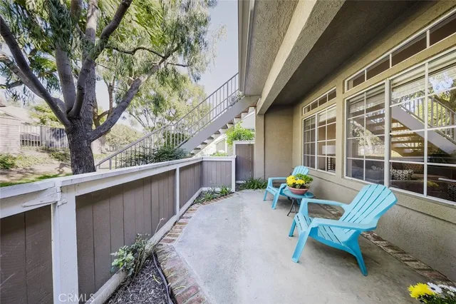 a view of a patio with a table and chairs and wooden fence