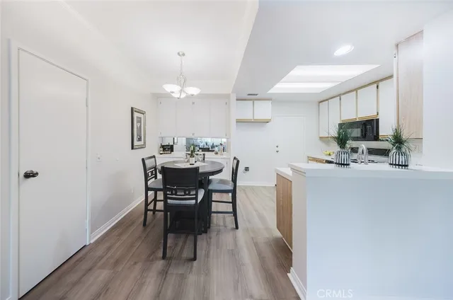 a kitchen with kitchen island a dining table chairs stainless steel appliances and cabinets