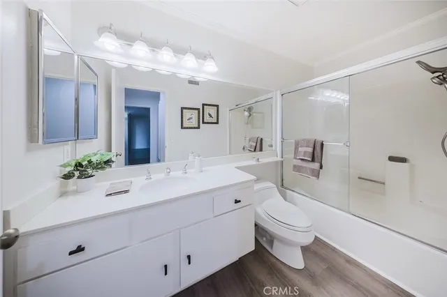 a bathroom with a sink vanity granite toilet and a mirror
