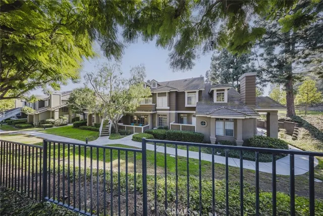 a front view of a house with a garden and trees