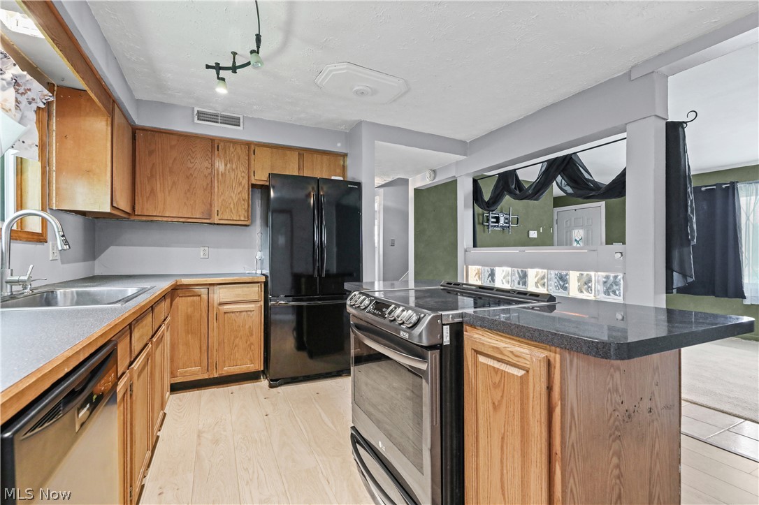 150 Graham Road Cuyahoga Falls, OH 44223 - Photo 13 of 38 Kitchen featuring wood cabinetry, black appliances, and a stainless steel sink