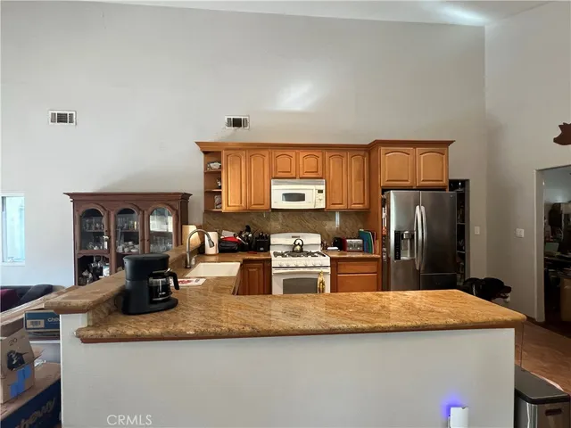 a kitchen with stainless steel appliances granite countertop a sink refrigerator and microwave