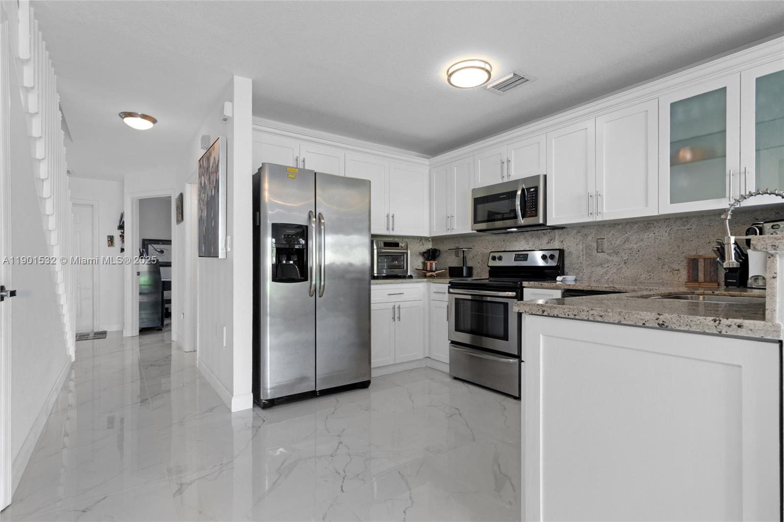 12905 Southwest 31st Court Miramar, FL 33027 - Photo 14 of 48 a kitchen with stainless steel appliances granite countertop a refrigerator a stove a sink and a microwave