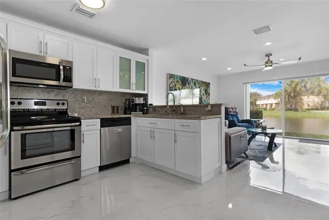 a kitchen with a sink cabinets and stainless steel appliances