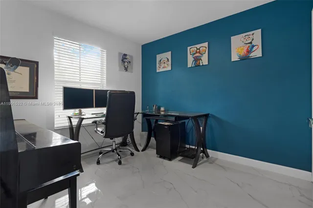 a view of a workspace with furniture and a window