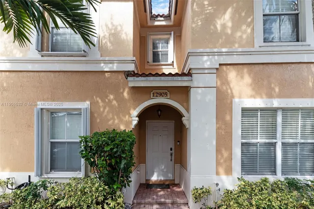 a front view of a house with plants