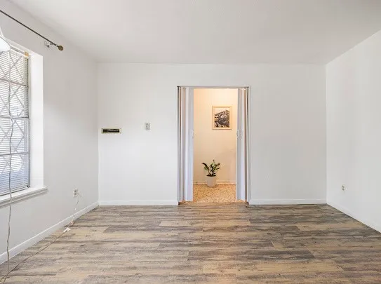 a view of a room with wooden floor and windows