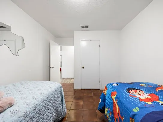 a bedroom with a bed and a painting on the wall