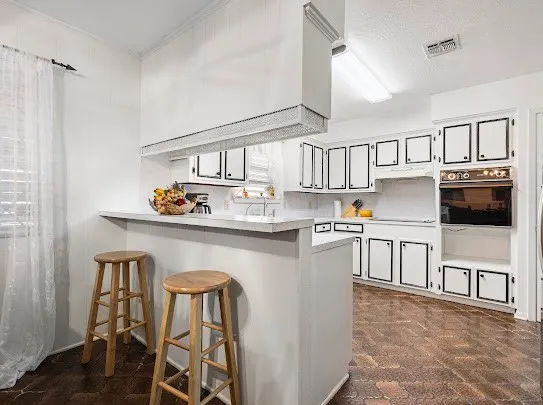 a kitchen with stainless steel appliances granite countertop a refrigerator a stove and a sink with wooden floor