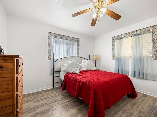 a bed sitting in a bedroom next to a window and a chandelier