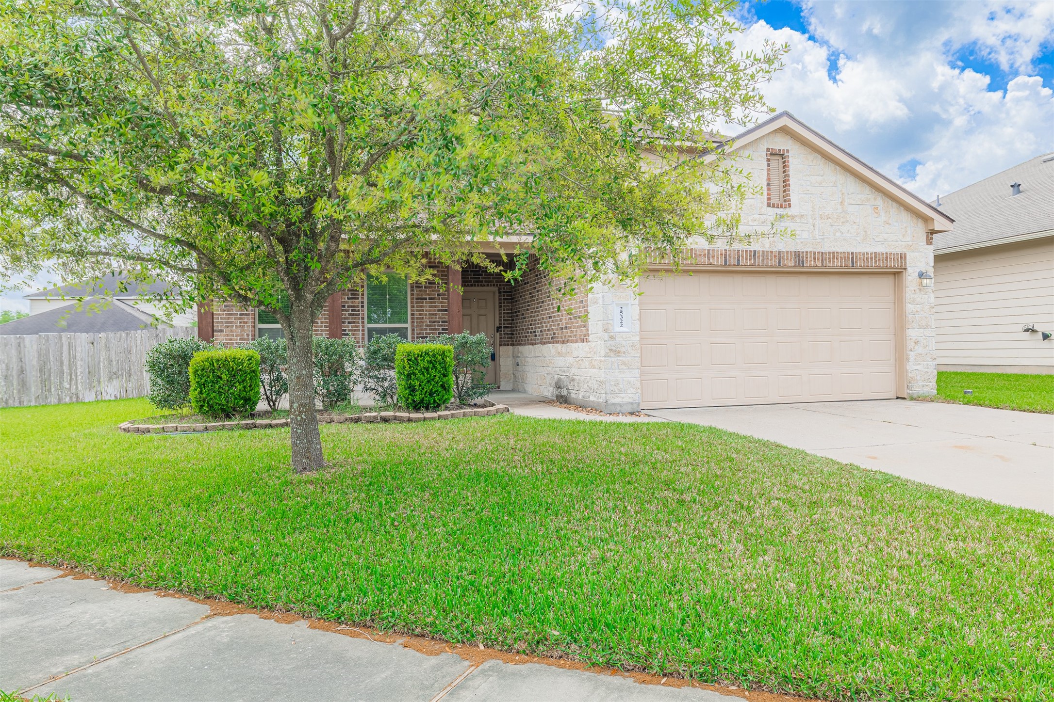 25322 Saddlebrook Ranch Drive Tomball, TX 77375 - Photo 2 of 20 a front view of a house with a garden and yard
