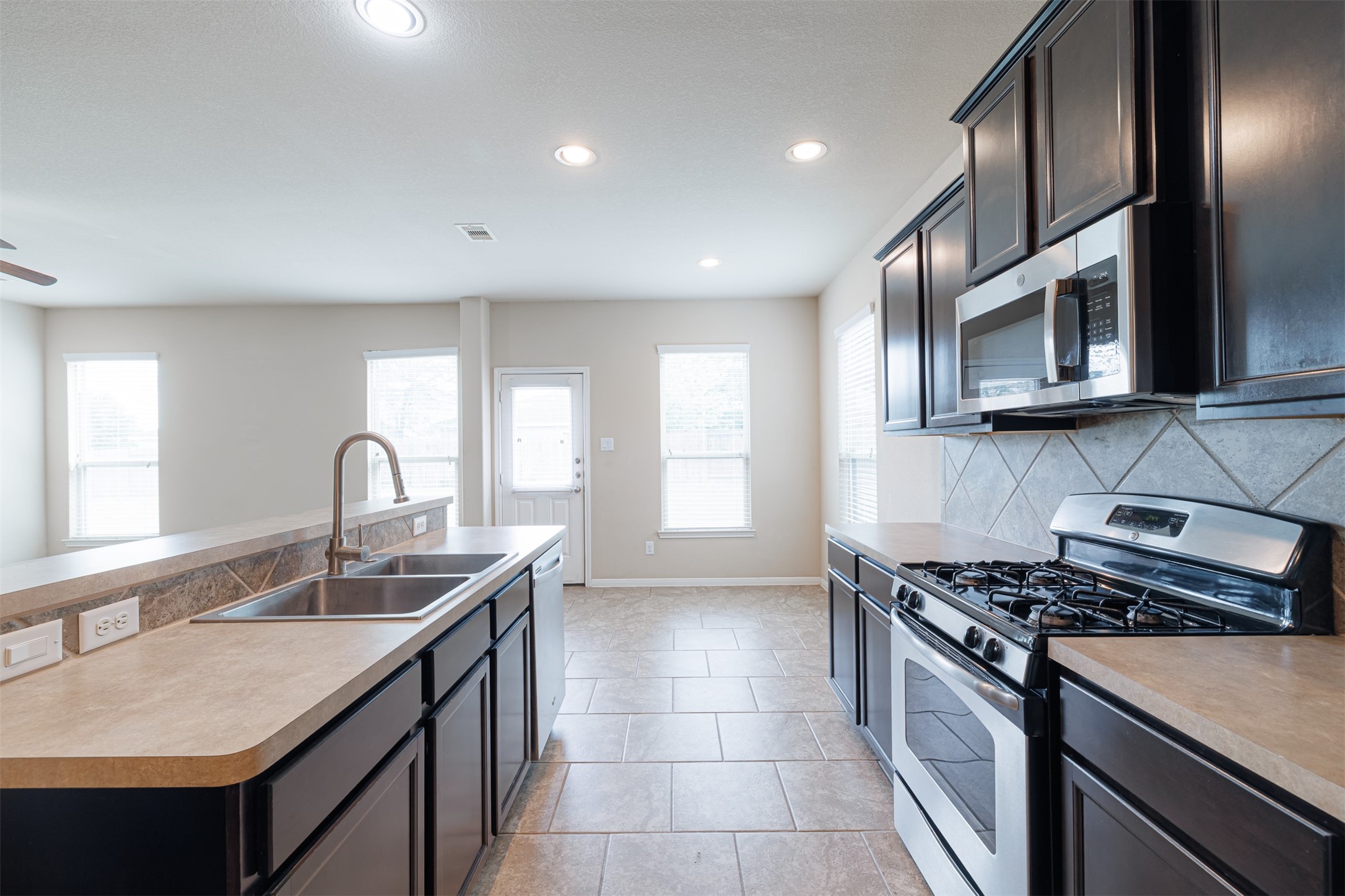 25322 Saddlebrook Ranch Drive Tomball, TX 77375 - Photo 4 of 20 a kitchen with stainless steel appliances granite countertop a sink stove and cabinets