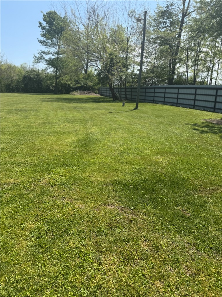5840 Pitchin Road South Springfield, OH 45502 - Photo 16 of 18 Expansive green yard offers serene outdoor living with mature trees and a sturdy fence.