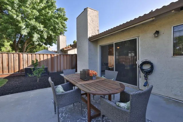 a view of a table and chairs in back yard of the house