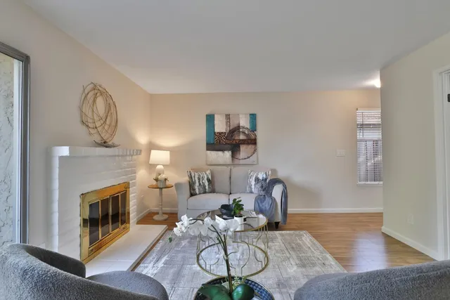 a living room with furniture a fireplace and a chandelier