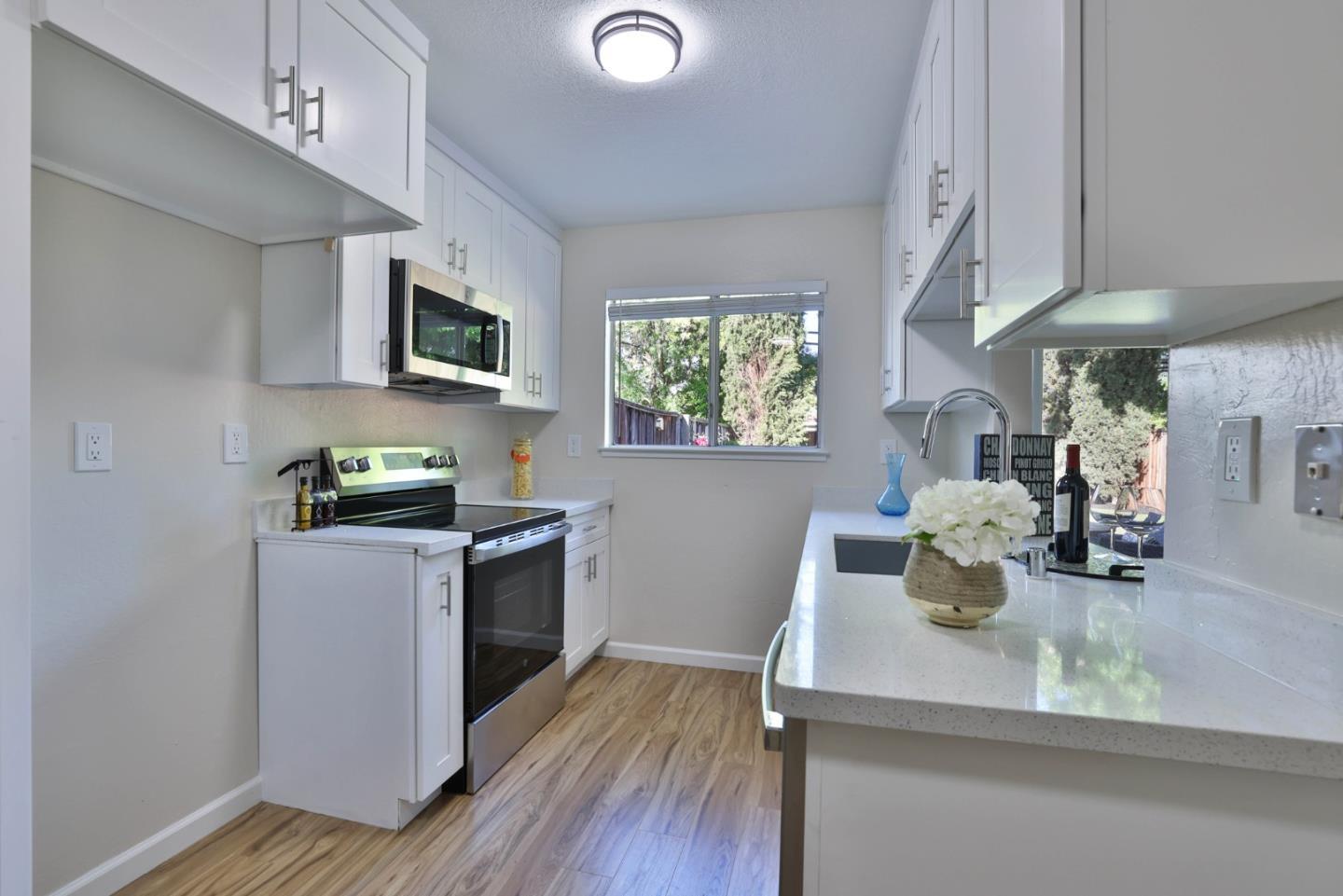 4648 Cherry Avenue San Jose, CA 95118 - Photo 7 of 29 a kitchen with stainless steel appliances white cabinets a sink a stove and a wooden floors