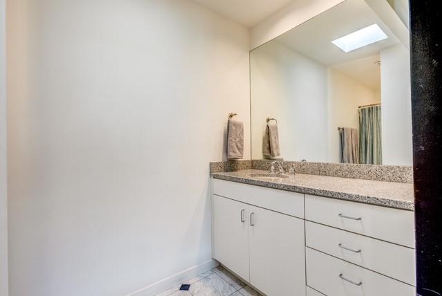 4122 Travis Street, Unit 2 Dallas, TX 75204 - Photo 13 of 19 a bathroom with a granite countertop sink and a mirror