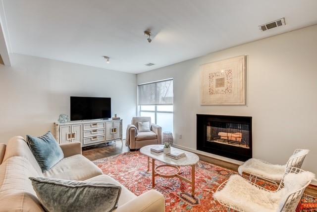 4122 Travis Street, Unit 2 Dallas, TX 75204 - Photo 2 of 19 a living room with furniture a fireplace and a flat screen tv