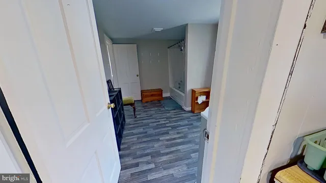 a view of a hallway with wooden floor and stairs