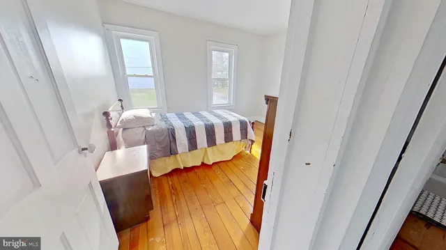 a bedroom with a bed and wooden floor
