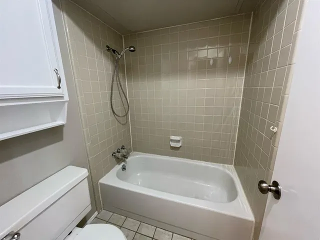 a white bath tub sitting next to a white sink and vanity
