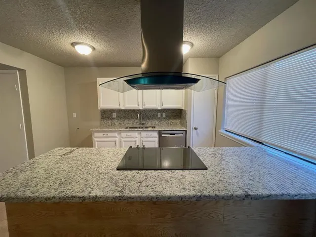 a kitchen with stainless steel appliances granite countertop a sink a stove and a refrigerator