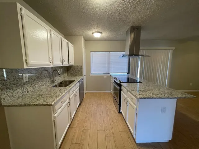 a kitchen with stainless steel appliances granite countertop wooden cabinets a sink and dishwasher