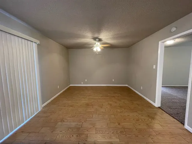 en empty room with windows and ceiling fan
