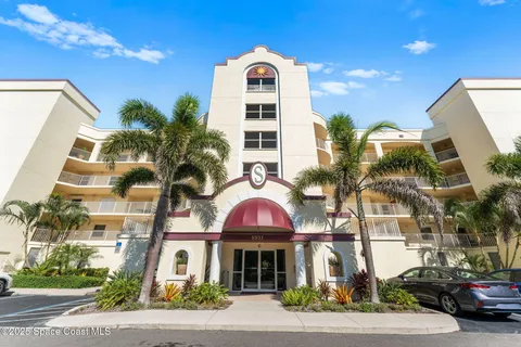 a front view of a multi story residential apartment building with a yard