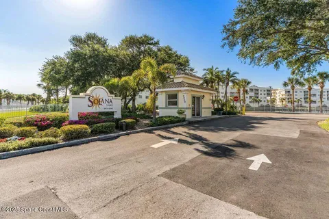 a front view of a house with a garden and tree