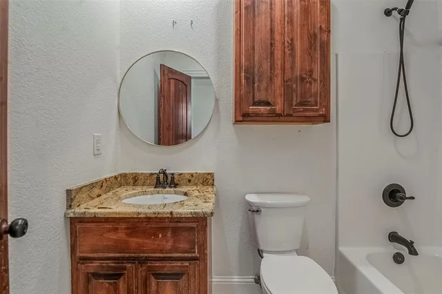 a bathroom with a toilet a sink and mirror