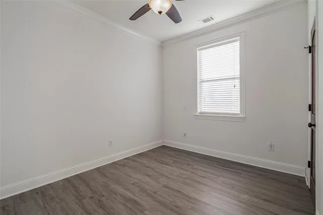 an empty room with a window and a ceiling fan