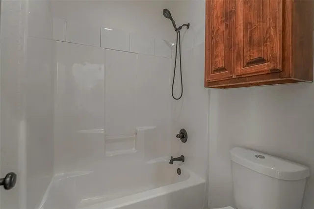 a bathroom with a shower a toilet and a shower