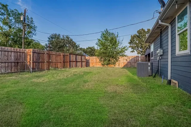 a backyard of a house with yard and trampoline