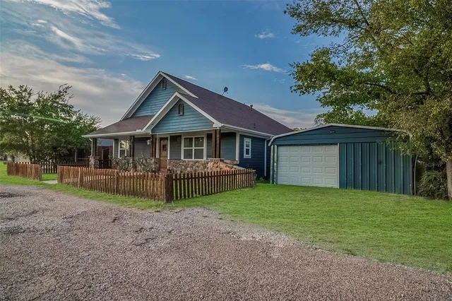 a view of a house with a yard and large tree