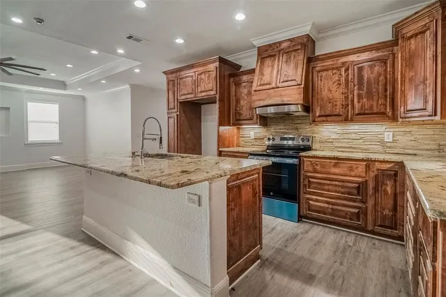 a kitchen with stainless steel appliances granite countertop a stove a sink and a refrigerator