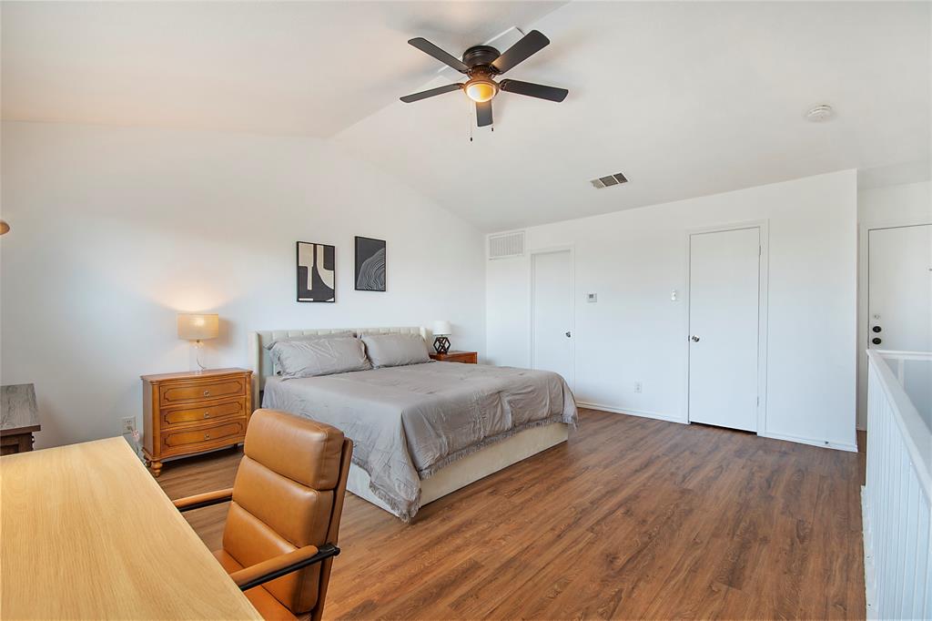 14277 Preston Road, Unit 823 Dallas, TX 75254 - Photo 19 of 31 Spacious room featuring vaulted ceilings, wood-finish flooring, a ceiling fan with integrated lighting, and multiple white panel doors