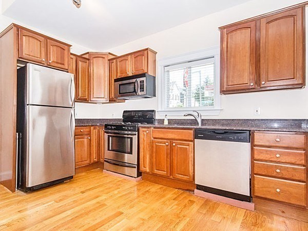 a kitchen with granite countertop stainless steel appliances a refrigerator stove and microwave