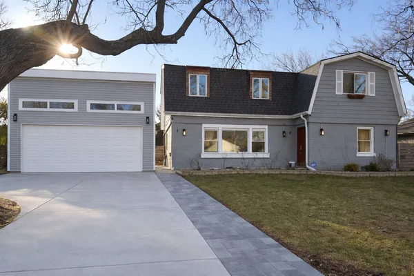 a front view of a house with a garden and yard