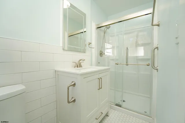 a bathroom with a shower sink and mirror