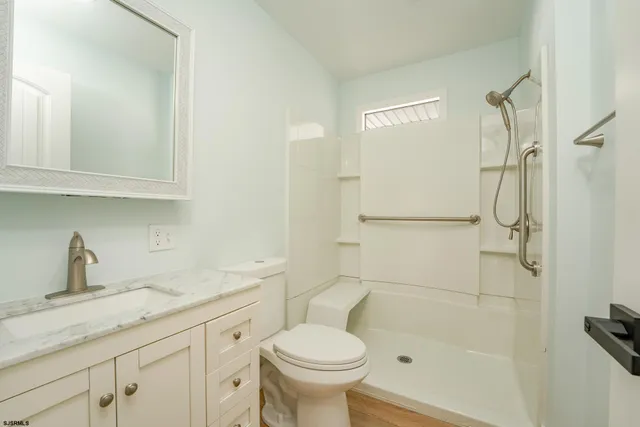 a bathroom with a granite countertop sink toilet and shower