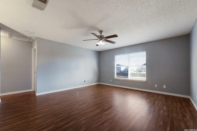 a view of an empty room with wooden floor