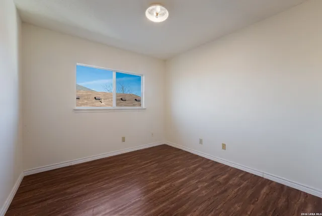 a view of a room that has wooden floor and white walls