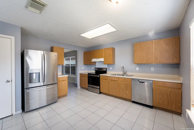 a kitchen with stainless steel appliances a refrigerator and a stove top oven
