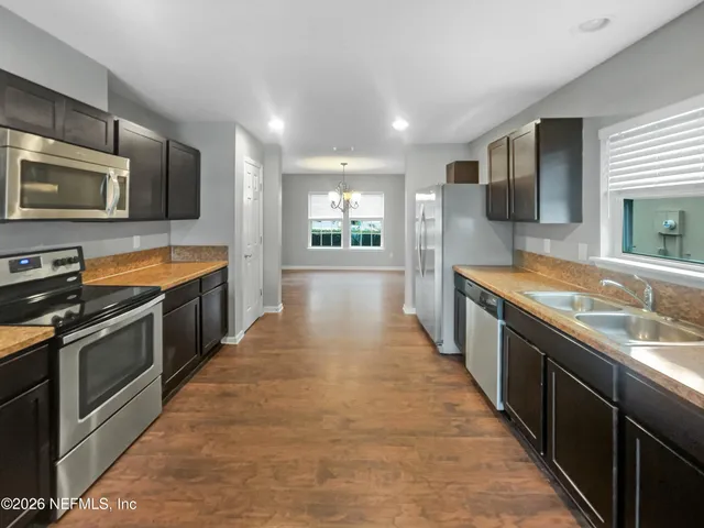a large kitchen with stainless steel appliances double cabinets and stainless steel appliances