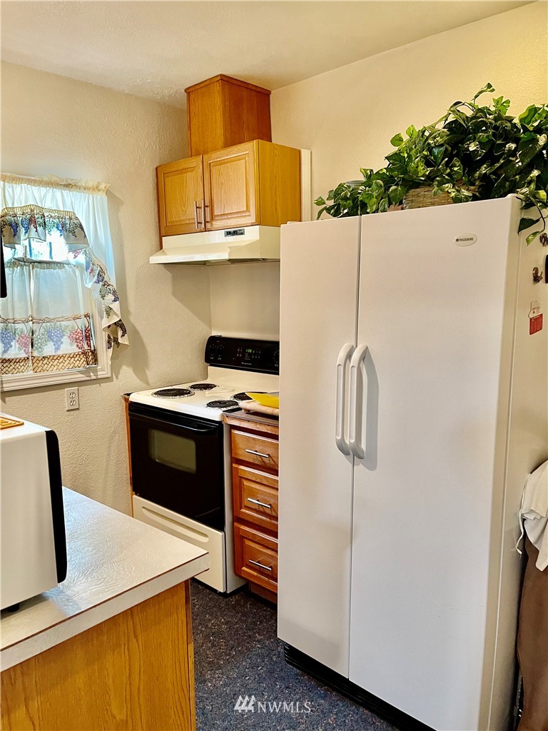 19225 Patterson Road East Orting, WA 98360 - Photo 19 of 34 a kitchen with stainless steel appliances a stove a refrigerator and a microwave