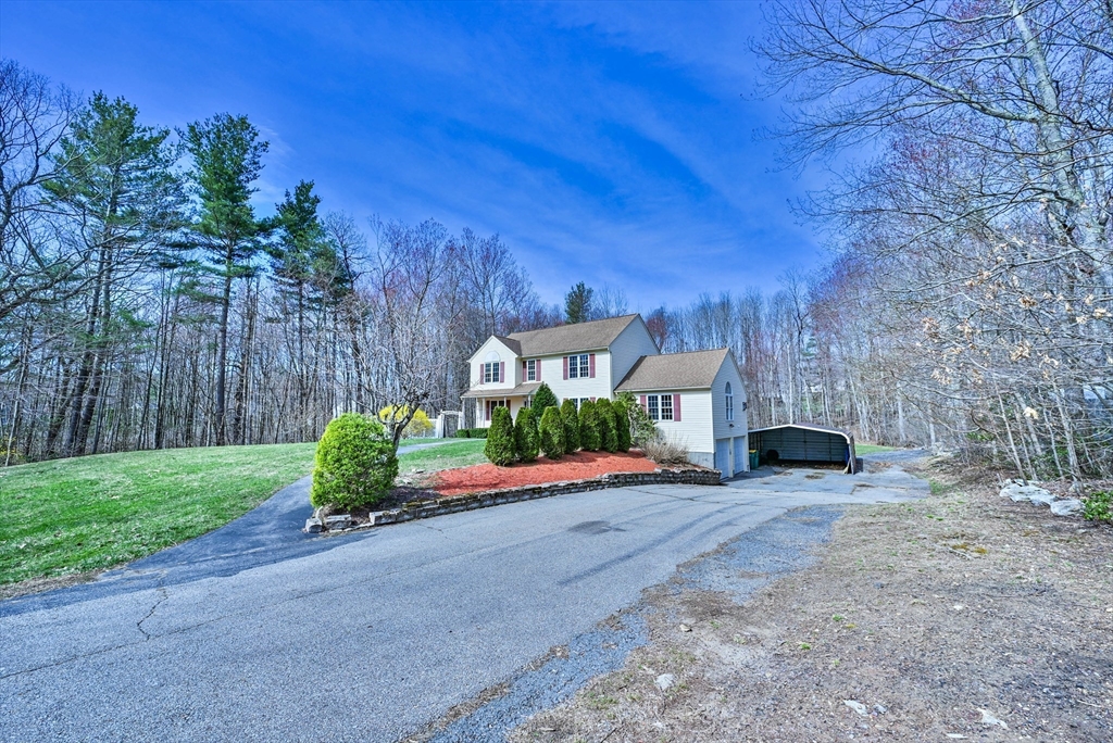 99 Smith Road Charlton, MA 01507 - Photo 2 of 37 a front view of a house with a yard and garage