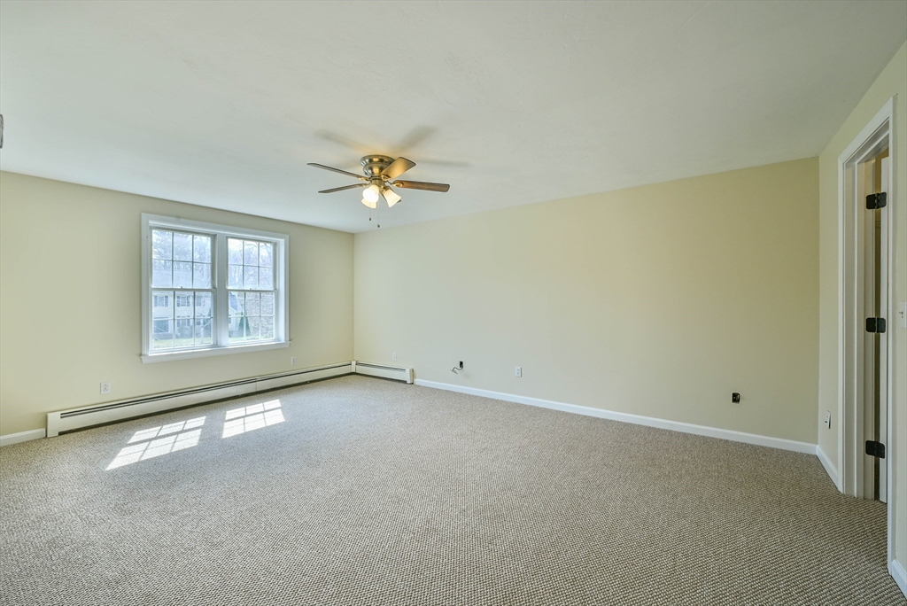 99 Smith Road Charlton, MA 01507 - Photo 28 of 37 an empty room with windows and chandelier fan