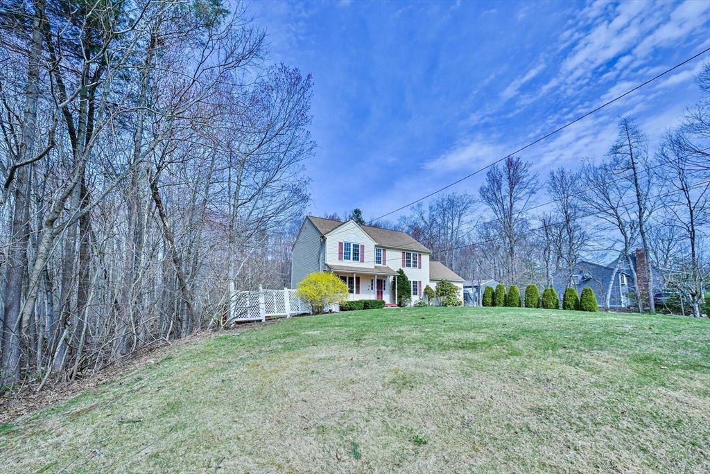 99 Smith Road Charlton, MA 01507 - Photo 5 of 37 a view of a house with a big yard and large trees