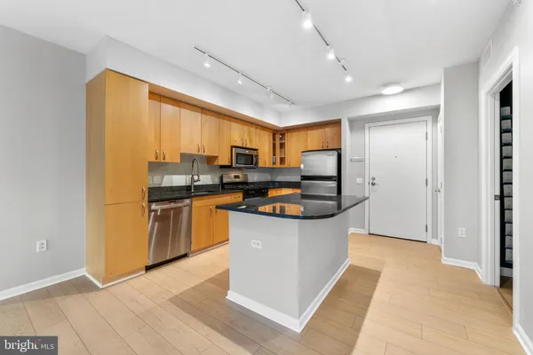 a kitchen with stainless steel appliances granite countertop a refrigerator a sink a stove and oven